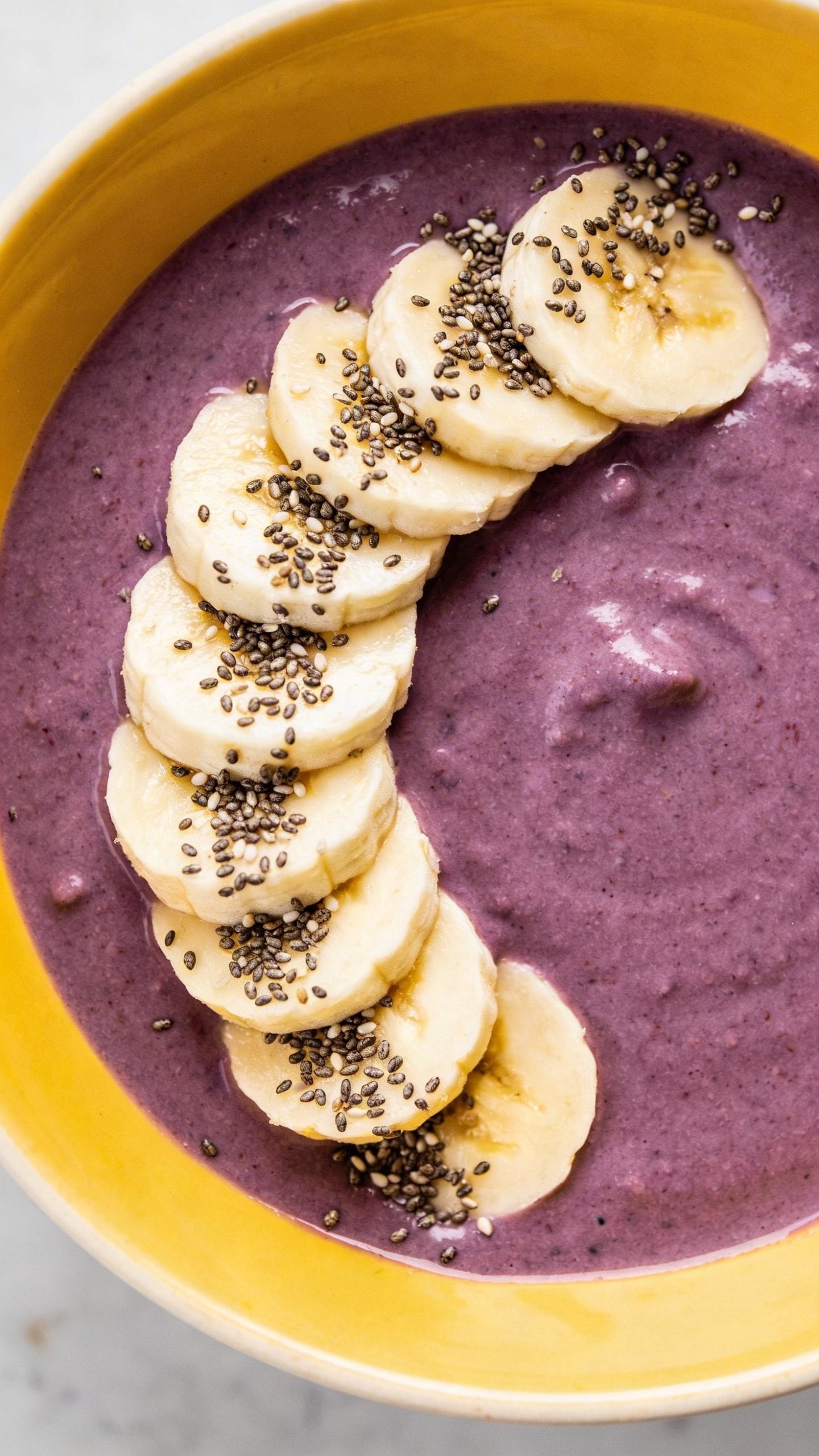 Overhead acai-protein smoothie bowl, sliced banana, hemp hearts